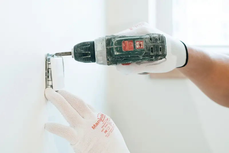 Perçage d'un mur blanc pour fixer une étagère