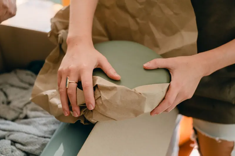 Vaisselle emballée dans du papier avant d'être mise en carton